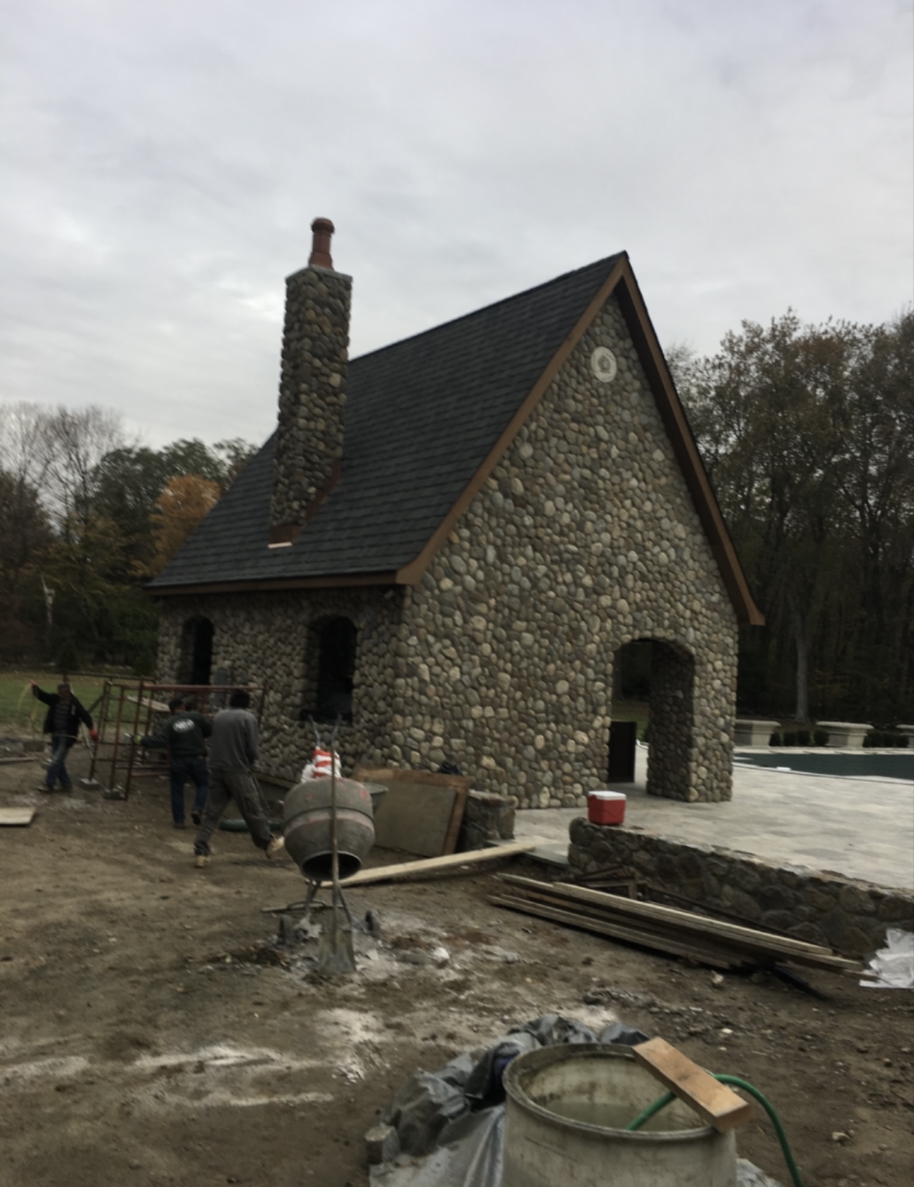 River stone pool house with stone chimney under construction